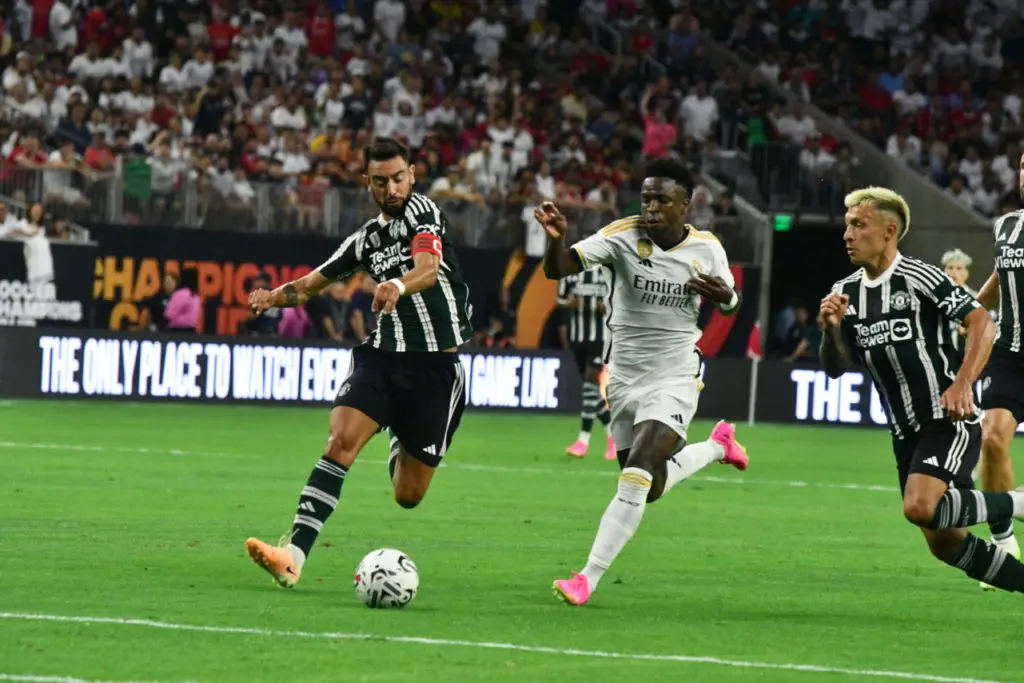 Manchester United's Portuguese captain Bruno Fernandes (left) and Argentine center back Lisandro Martinez (right) track Real Madrid's Brazilian prodigy Vinicius Jose Paixao. Photo by Maya Shea Ortiz.